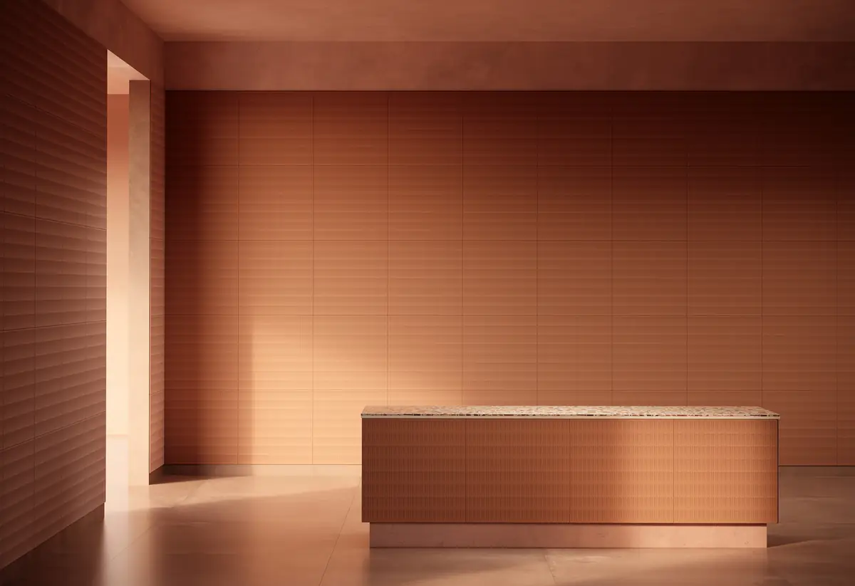 Sala con paredes y mostrador revestidos de paneles en tono terracota y luz rasante