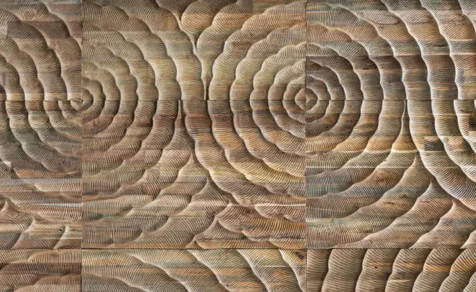 Paneles de madera tallados con relieves concéntricos que recuerdan a olas