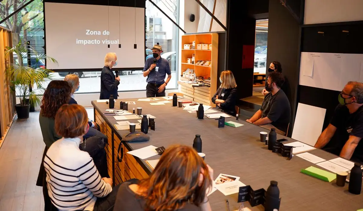 Sala de Matter Barcelona con una proyección sobre la zona de impacto visual y participantes en la mesa