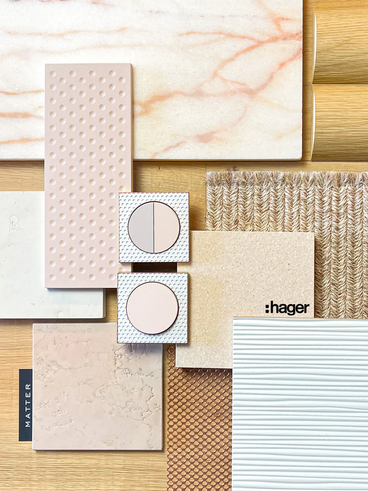 Composición con dos mecanismos de marco de chapa perforada blanca y teclas rosas, una doble y otra simple, entre mármol, cerámica en relieve y sisal