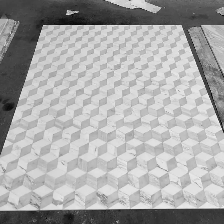 Mosaico de mármol con dibujo geométrico de cubos en relieve, en blanco y gris