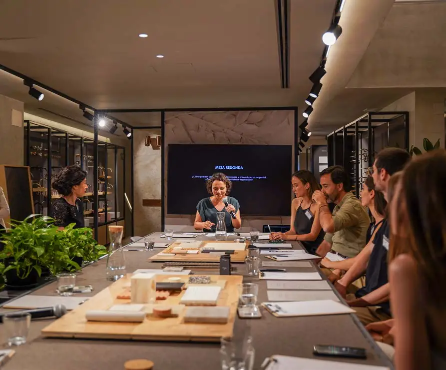 Ponentes y asistentes sentados alrededor de la mesa de materiales de Matter durante la mesa redonda