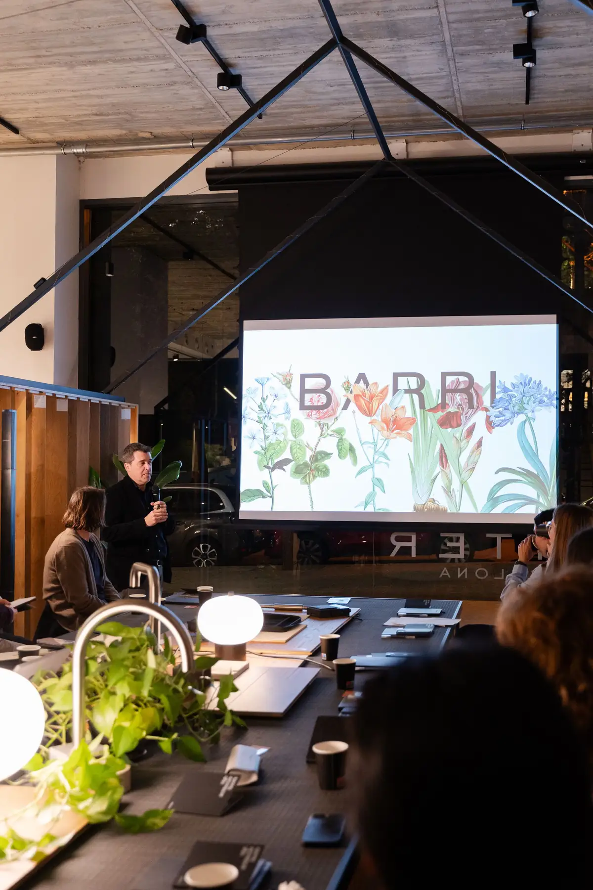 Pantalla con el nombre de Barri Studio e ilustraciones botánicas durante una ponencia