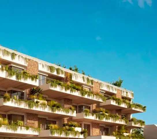 Fachada residencial con terrazas escalonadas cubiertas de vegetación bajo un cielo azul