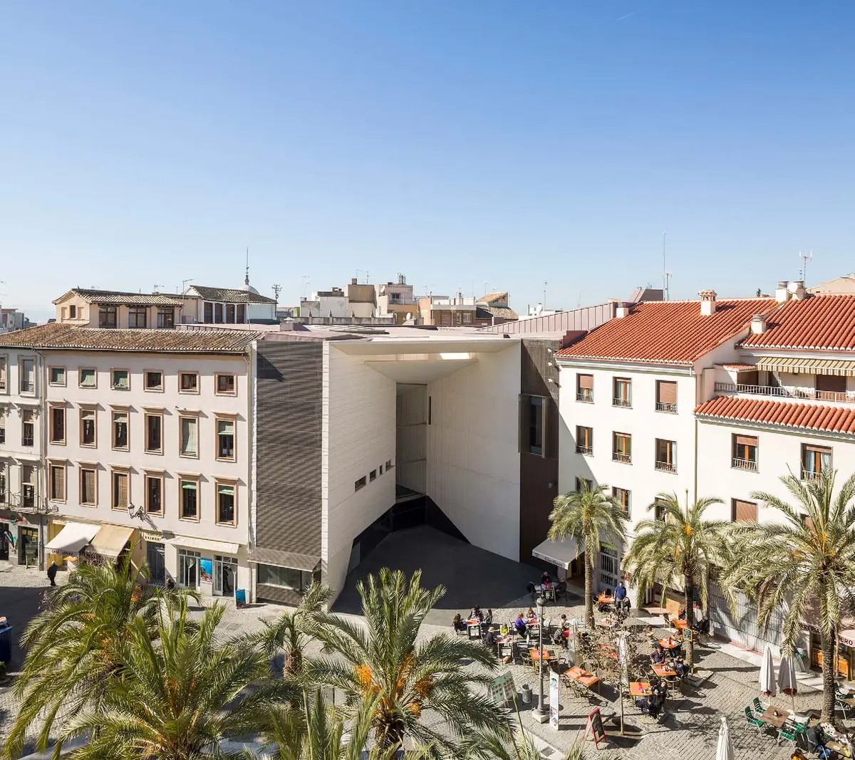 Vista aérea del Centro Federico García Lorca abierto a una plaza con palmeras en el centro de Granada