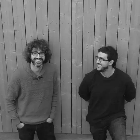 Retrato en blanco y negro de Marc Alventosa y Xavier Morell ante un muro de madera