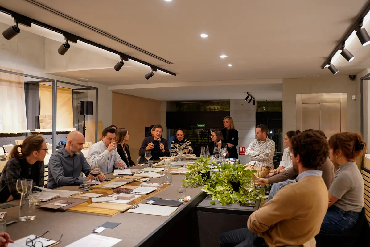Asistentes sentados alrededor de la mesa de materiales de Matter Madrid escuchando una intervención