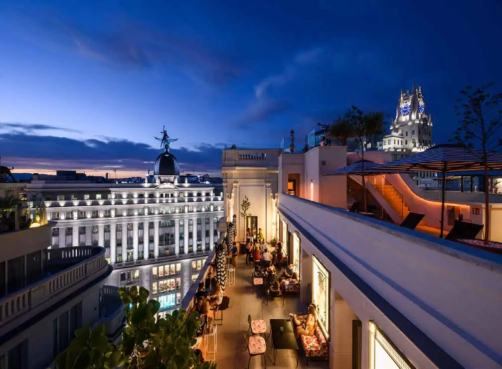 Terraza en azotea al anochecer con vistas a los edificios históricos y las cúpulas de Madrid
