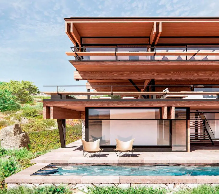 Vivienda con voladizos y aleros de madera sobre una piscina y una ladera con vegetación