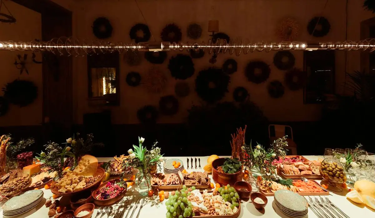Mesa con comida iluminada por una luminaria lineal de vidrio en un interior oscuro