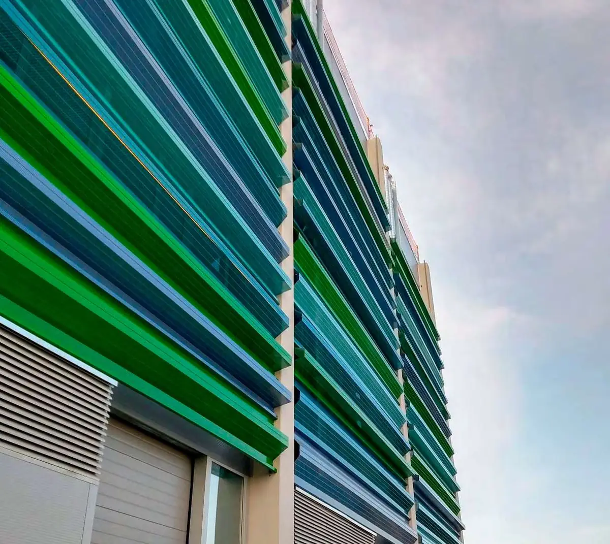 Fachada con lamas en tonos verdes y azules del edificio Gonsi Sócrates