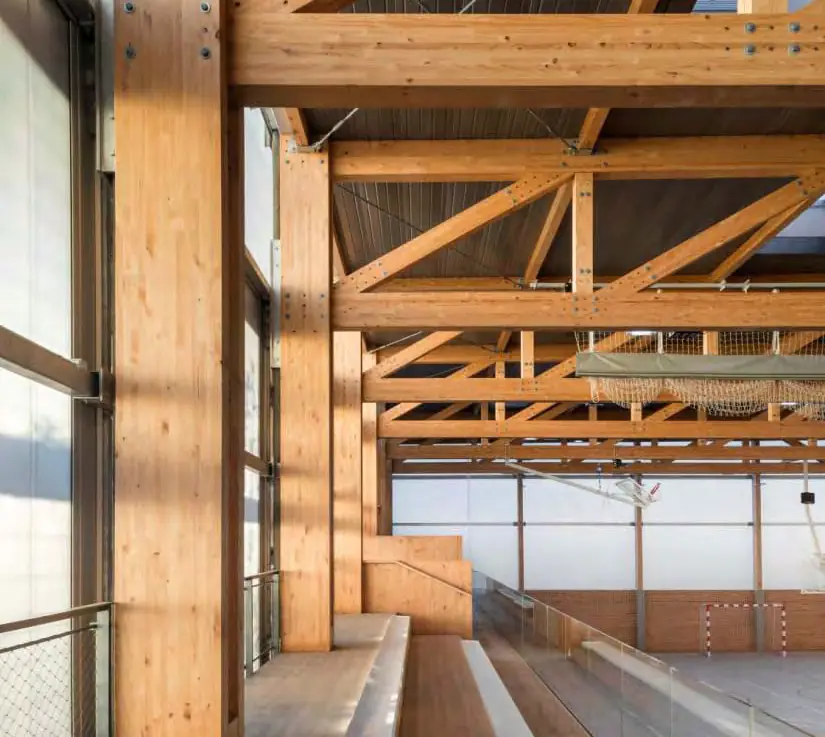 Gradas y estructura de madera laminada junto a la pista del polideportivo Turó de la Peira