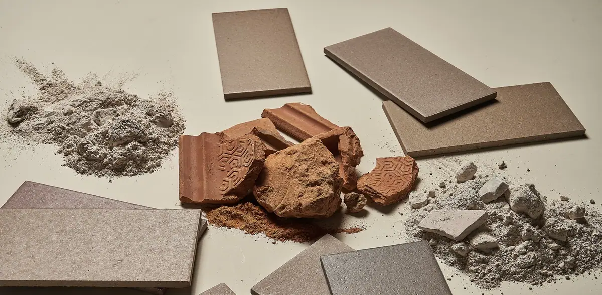 Fragmentos de terracota, polvo y restos de piedra junto a baldosas cerámicas acabadas