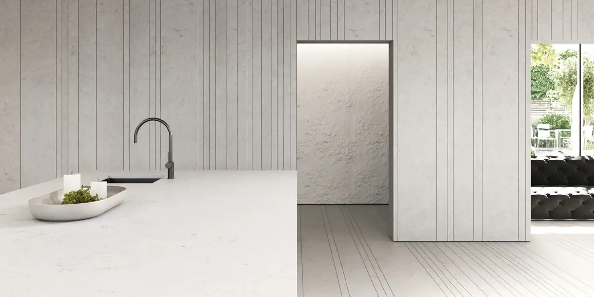 Cocina con isla de Obsidiana Volcano Light y paredes y suelo claros con juntas verticales