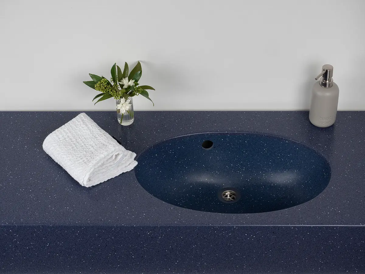 Encimera de superficie sólida azul oscuro con un lavabo ovalado integrado del mismo material