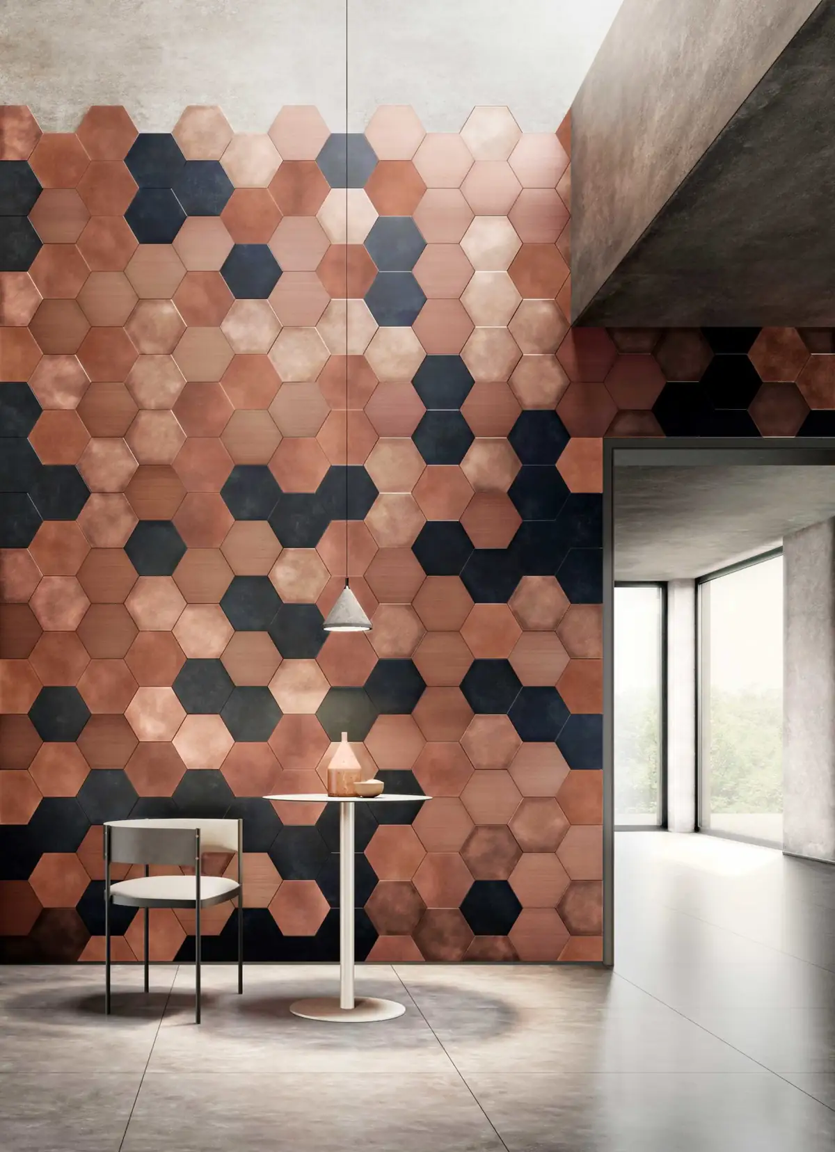 Pared de doble altura revestida con piezas hexagonales metálicas en tonos cobre y negro, con una mesa y una silla delante