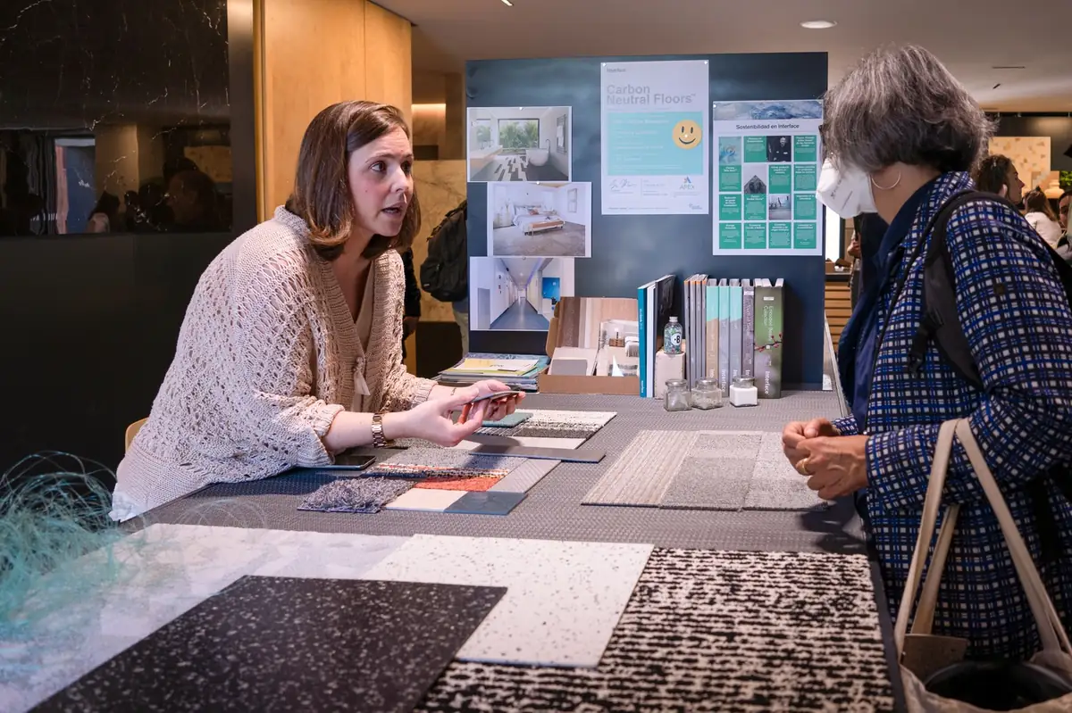Conversación ante una mesa con muestras textiles y de pavimento
