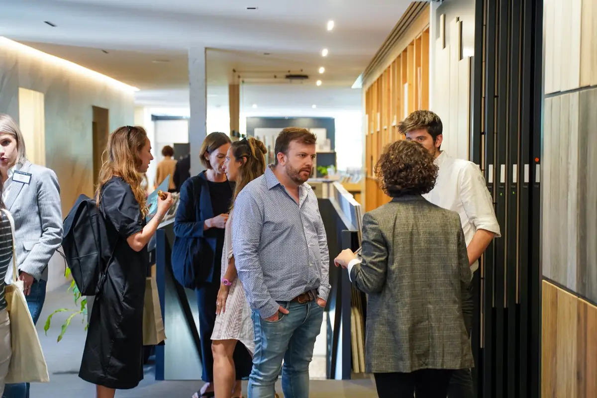 Grupo de visitantes conversando en el pasillo de la exposición