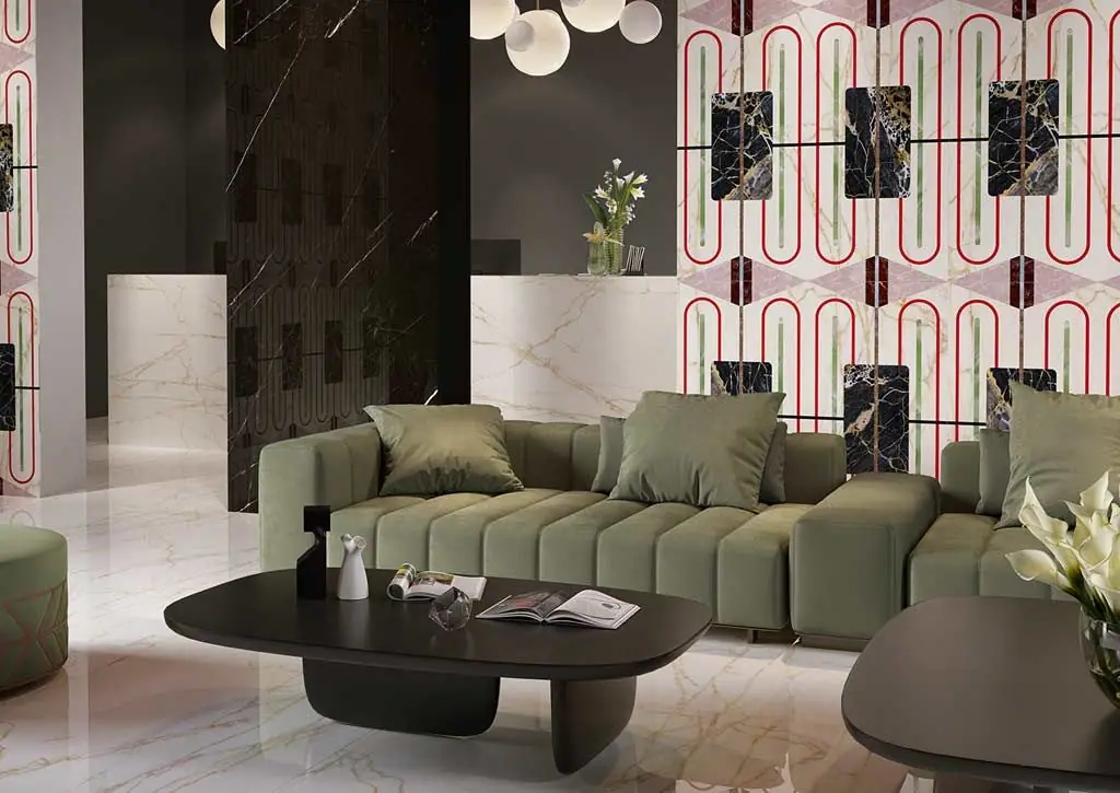 Vestíbulo con sofá verde frente a una pared de placas blancas con motivos ovalados rojos y paneles de mármol oscuro.