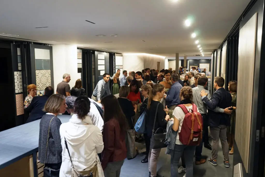 Pasillo lleno de invitados entre paneles expositores de cerámica