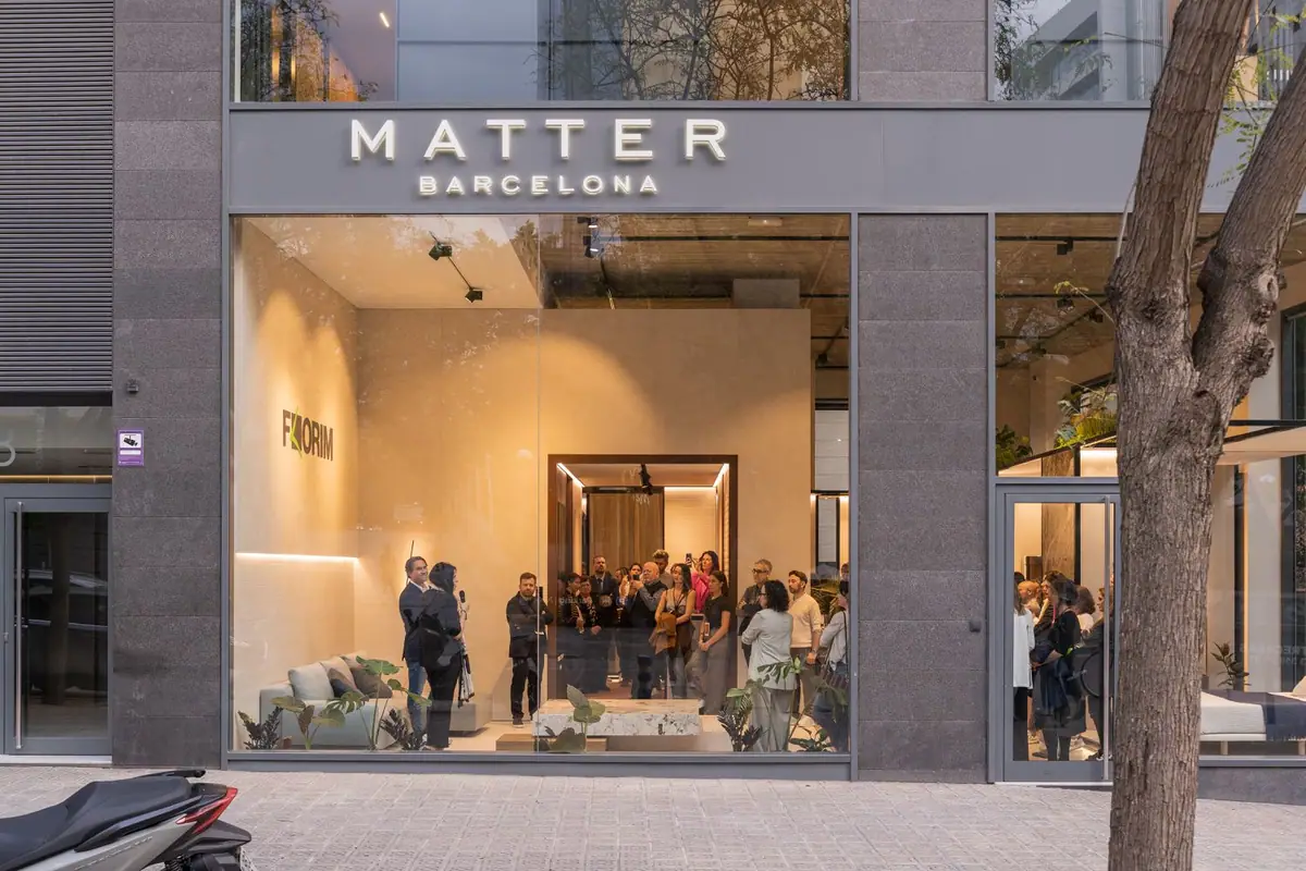Fachada de Matter Barcelona al anochecer, con el público de la inauguración tras el escaparate