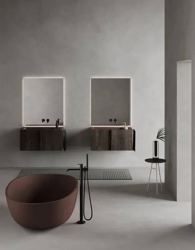 Dos módulos Paral suspendidos en madera oscura con lavabos color terracota, espejos retroiluminados y una bañera exenta en primer plano.