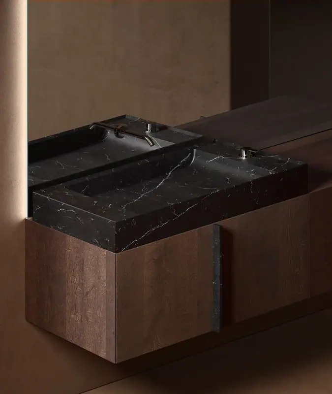 Lavabo rectangular de mármol negro con vetas blancas sobre un módulo Paral de roble oscuro, con tirador vertical de mármol.