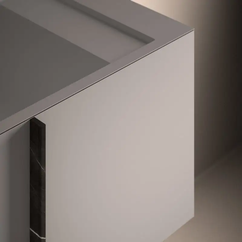 Detalle de la esquina de un módulo Paral blanco, con la tapa de Solidsurface y un tirador vertical de mármol oscuro.