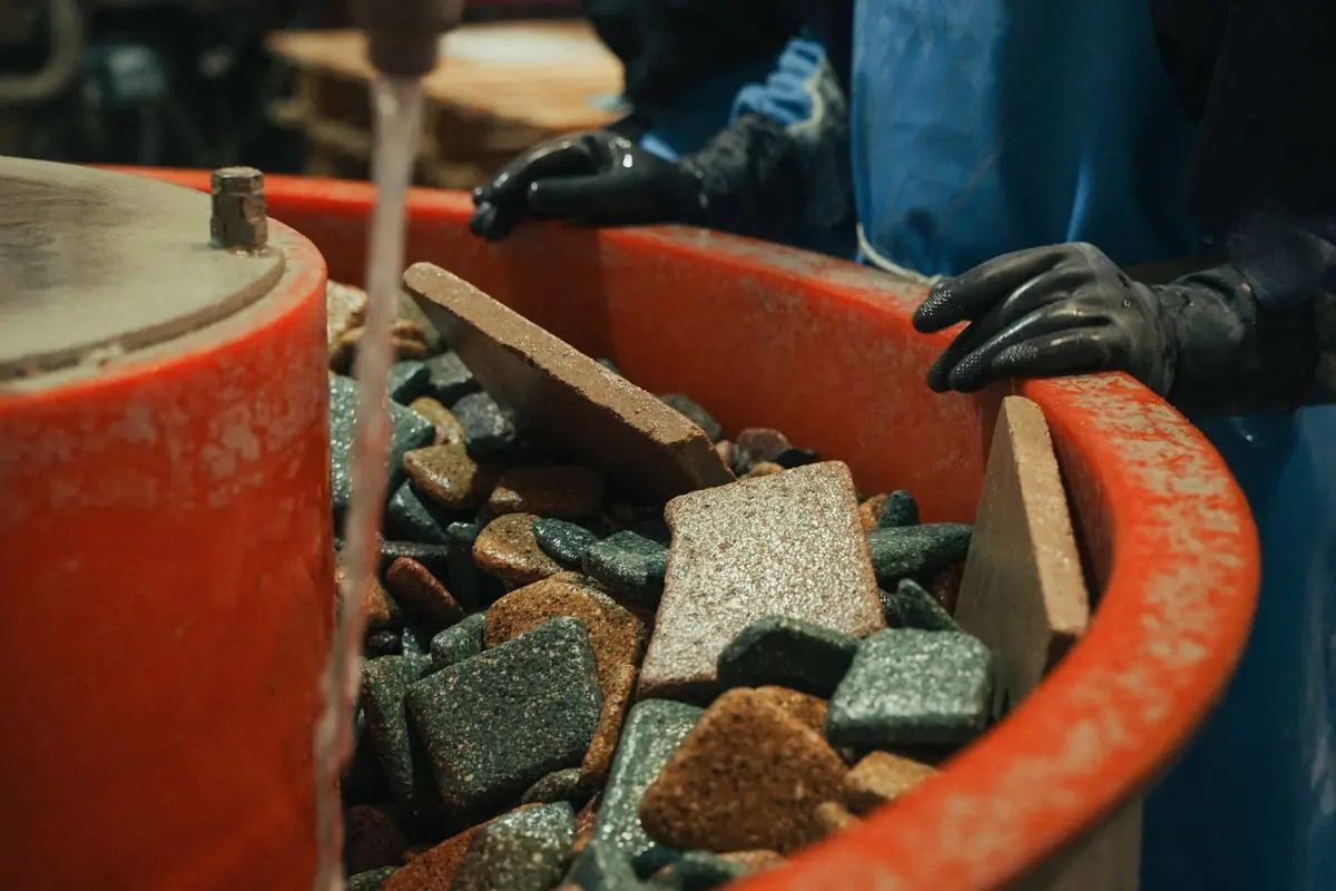 Piezas de piedra compactada dentro de un bombo de volteo con agua
