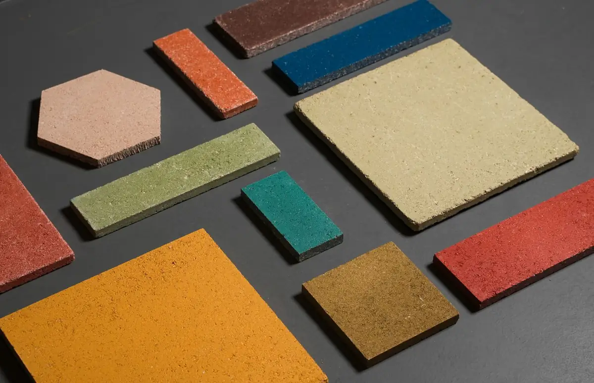 Piezas de piedra compactada de distintos formatos y colores sobre fondo gris