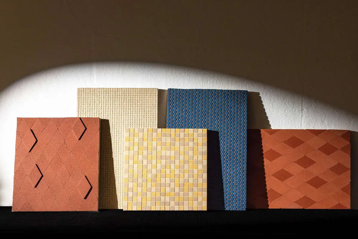Paneles de muestra con mosaicos de piedra compactada en rombos, cuadrados y círculos de varios colores