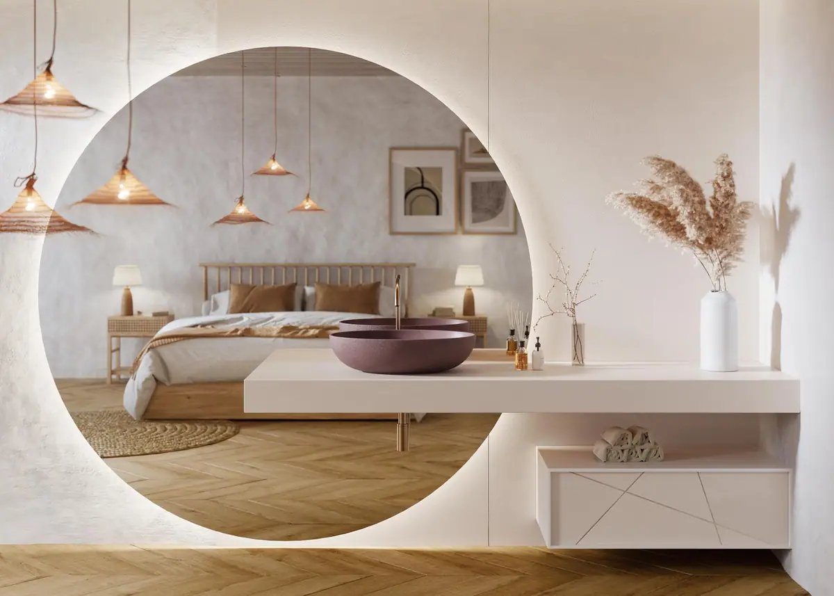 Lavabo ovalado de apoyo sobre una encimera blanca volada, con mueble suspendido y un gran espejo circular retroiluminado
