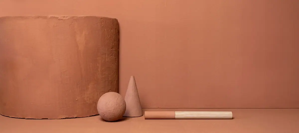 Bloque cilíndrico, esfera, cono y varilla revestidos en terracota sobre un fondo del mismo color