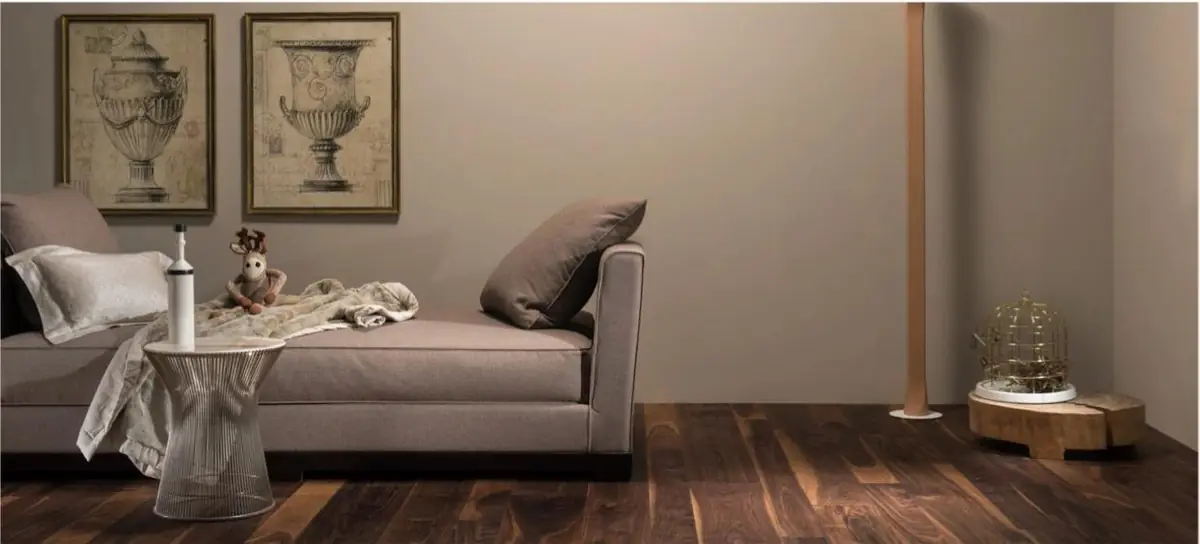 Salón con chaise longue gris y suelo de tablas de madera oscura con vetas claras