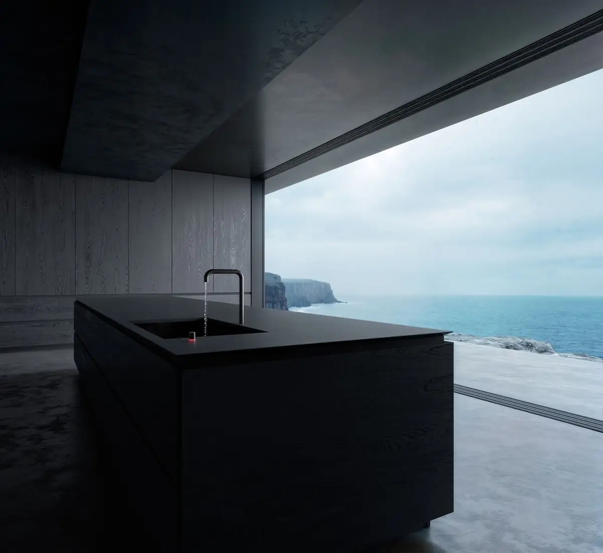 Cocina con isla negra y grifo negro frente a un gran ventanal con vistas al mar