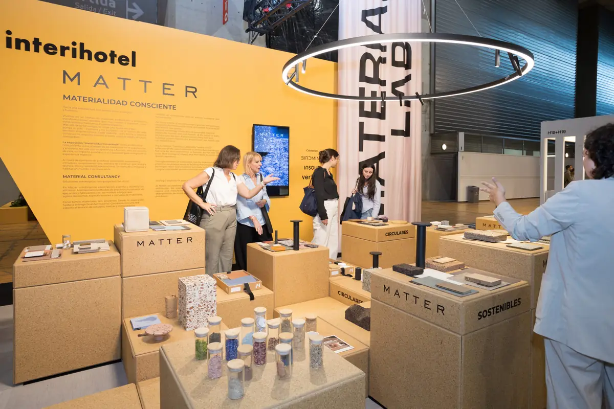 Visitantes recorren la exposición Materialidad Consciente entre peanas con muestras de materiales y el panel amarillo de Matter