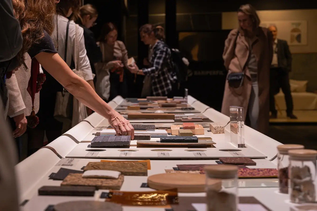 Una visitante toca una de las muestras dispuestas sobre la mesa impresa en 3D.