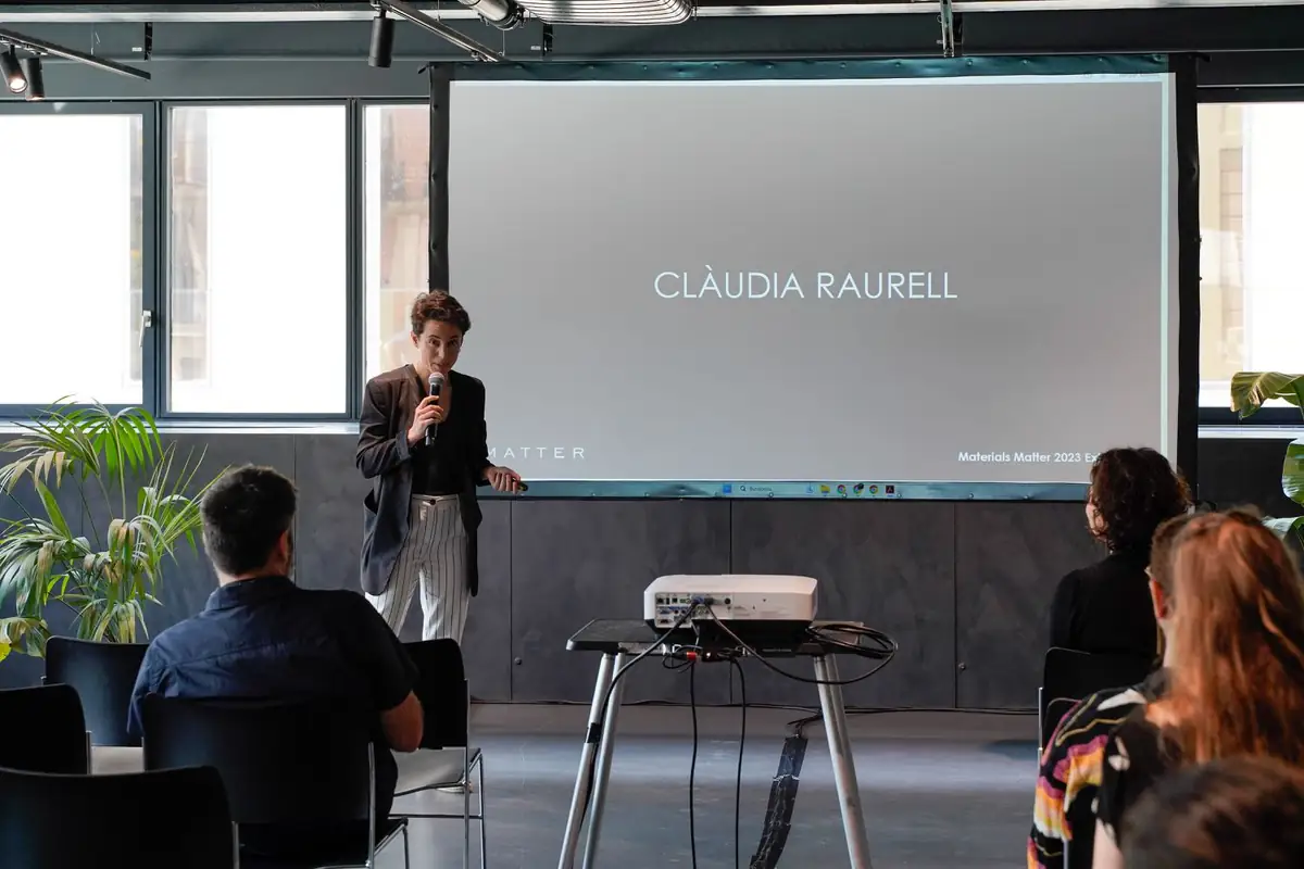 Ponente con micrófono ante una pantalla con el nombre de Clàudia Raurell.