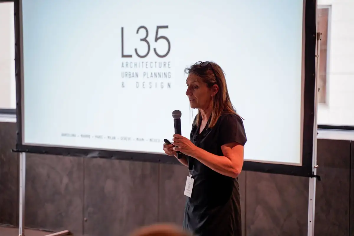 Ponente con micrófono ante una diapositiva con el logotipo de L35.