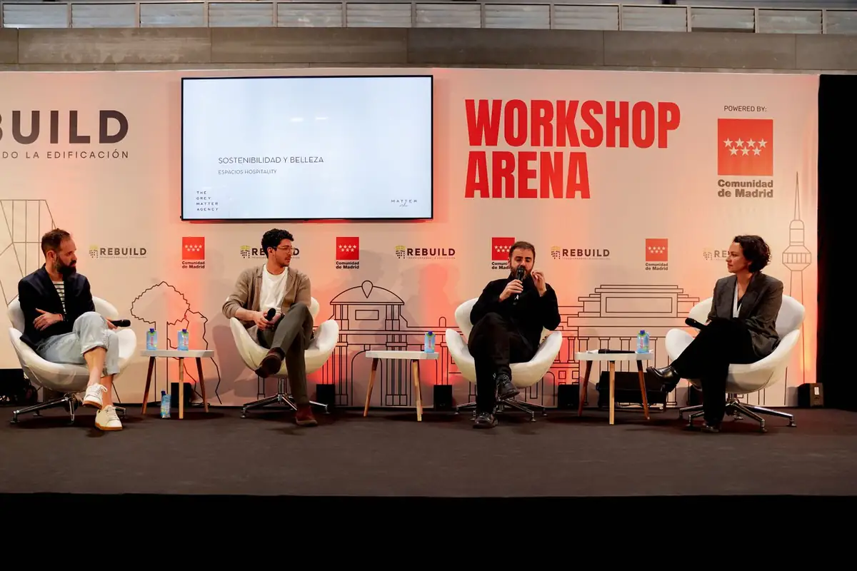 Cuatro ponentes en el escenario del Workshop Arena; uno de ellos habla con micrófono