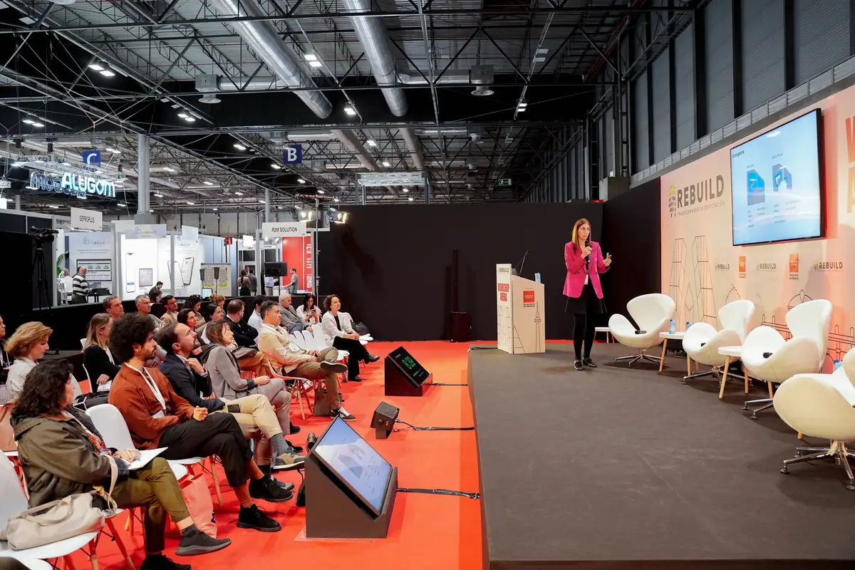 Una ponente de pie habla ante el público en el Auditorio Workshop Arena
