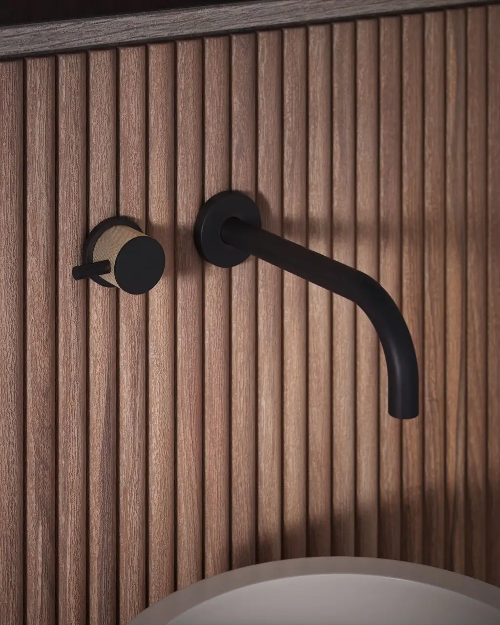 Grifo de lavabo mural negro con mando moleteado sobre un revestimiento de listones de madera