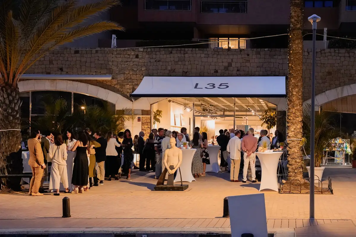 Invitados reunidos de noche frente al local iluminado de L35