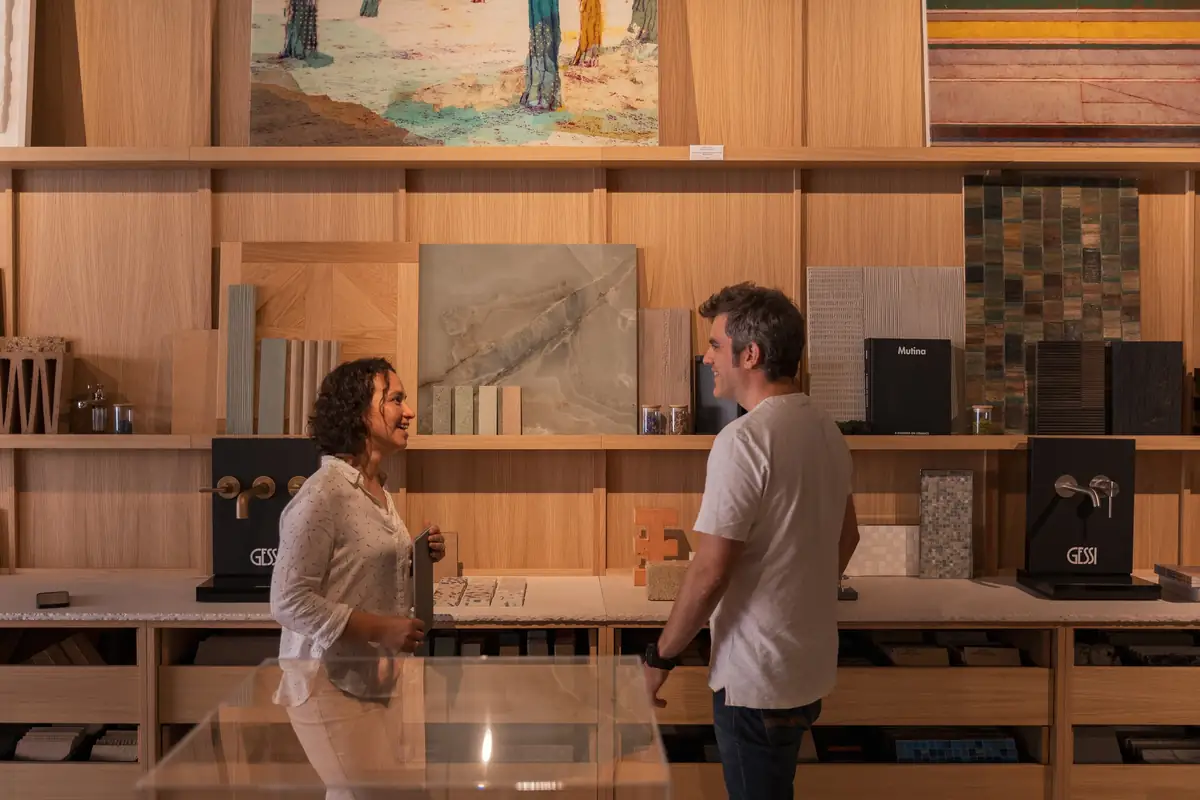 Dos personas conversan frente a las estanterías de muestras de materiales