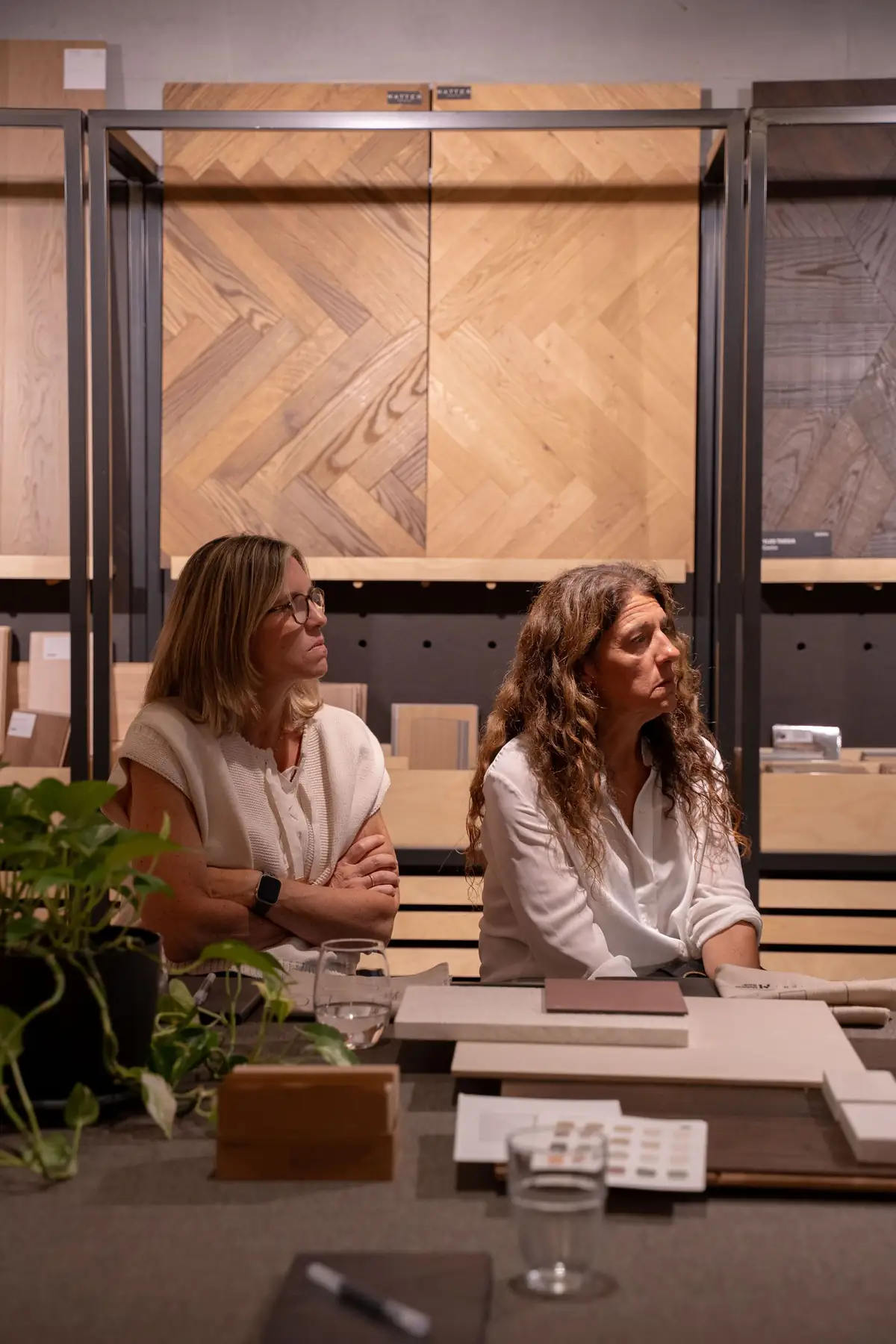 Dos asistentes siguen la charla sentadas a la mesa de materiales.