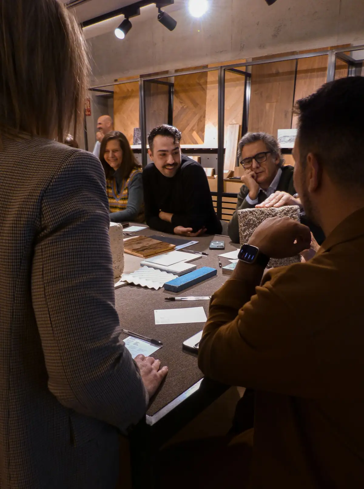 Asistentes conversando alrededor de una mesa con muestras de materiales en Matter Madrid.