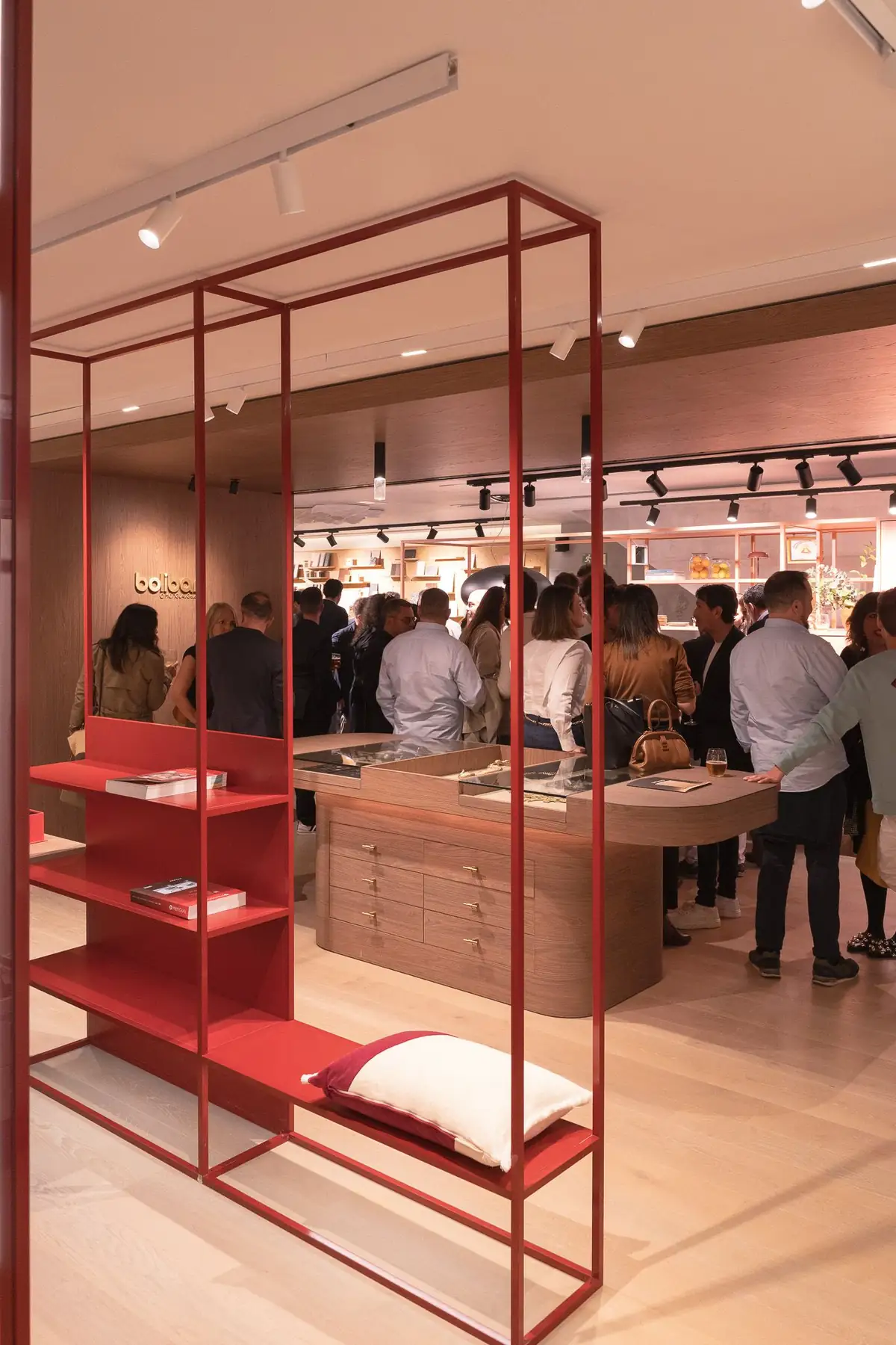 Estantería de estructura metálica roja con libros en uno de los espacios expositivos