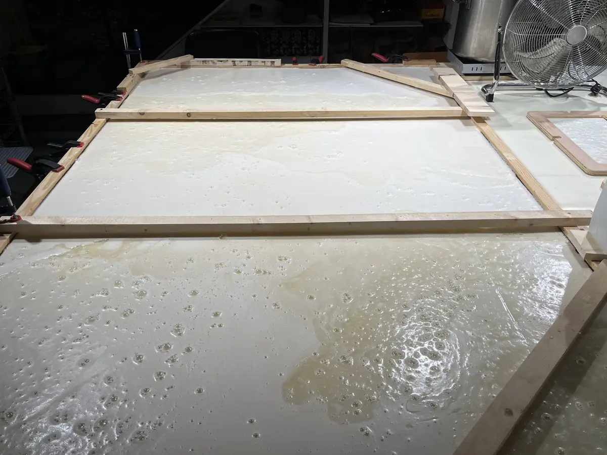 Bastidores de madera con una espuma blanca extendida en el suelo de un taller