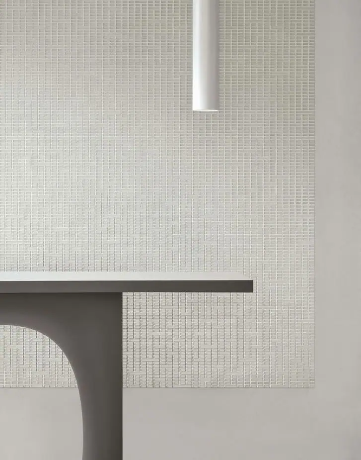 Detalle de un paño de Matter Uren en tono claro, con teselas rectangulares de varias longitudes, junto al canto de una consola.