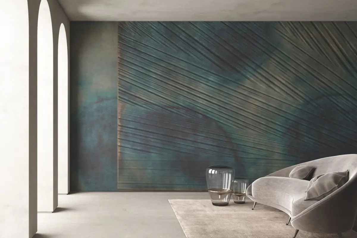 Sala de estar con sofá curvo ante una pared en azul verdoso con líneas en relieve que forman un abanico